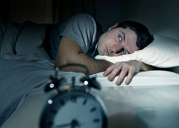 Man in bed lying awake at night.