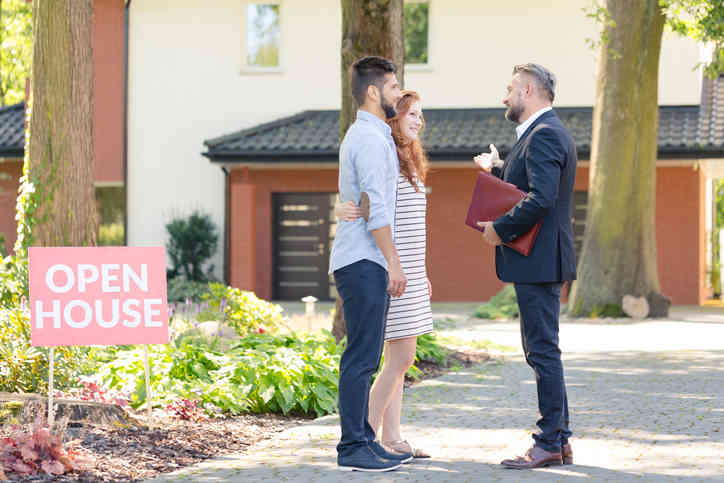 Realtor showing a young couple a home.
