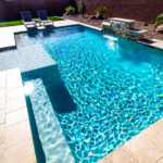 A clean swimming pool with a waterfall.