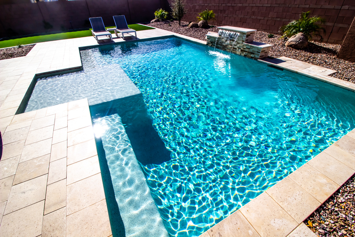 A clean swimming pool with a waterfall.